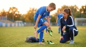 an image of a soccer player at the field pointing at the heel showing coach their in pain