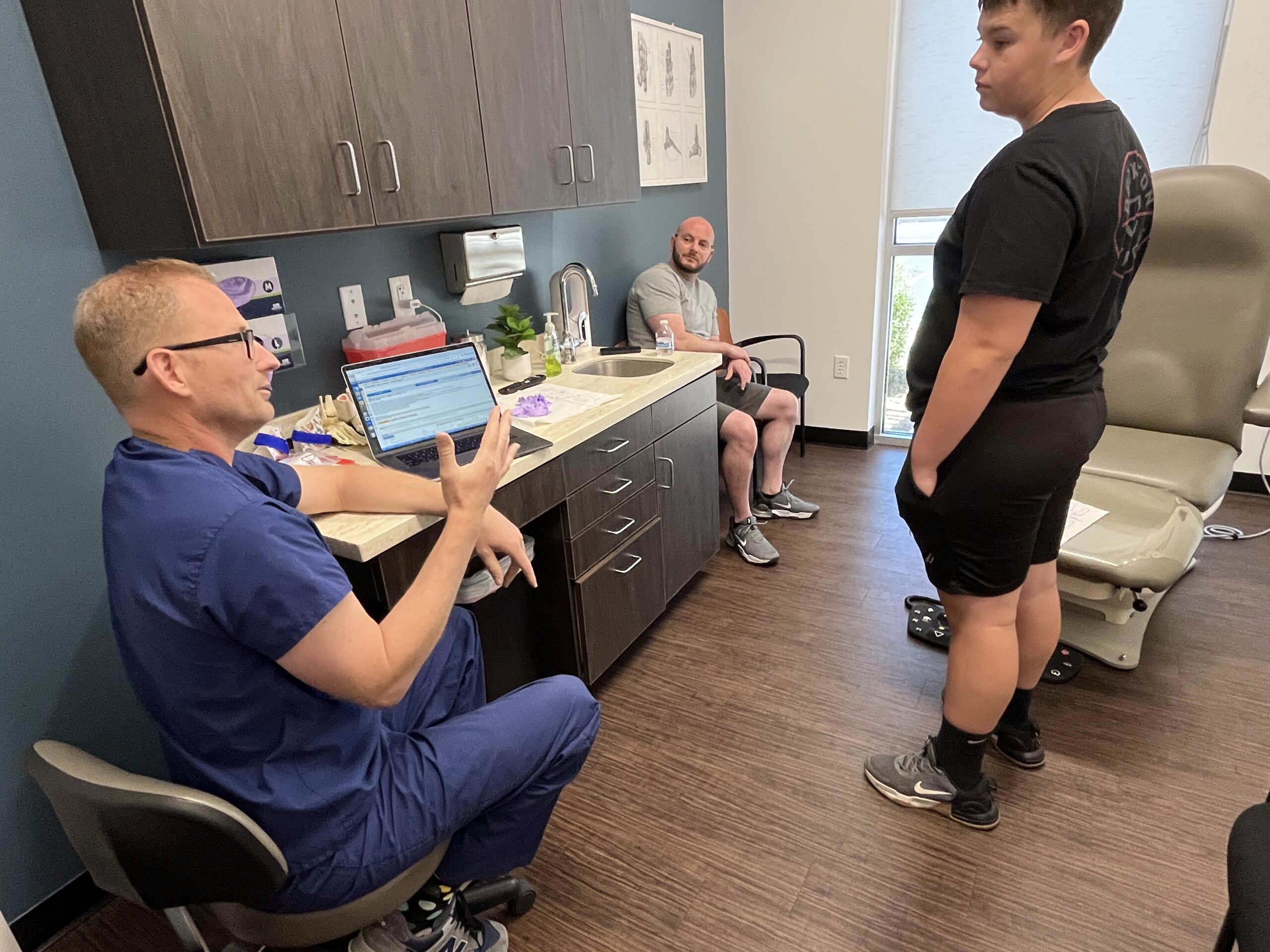 Pediatric patient standing with Dr. Jarman during a foot and ankle evaluation in the Chandler, AZ clinic.